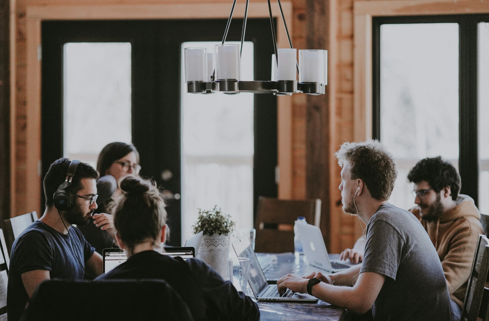 A small agency team collaborating around a table in a warm, sunlit studio